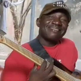 Alas Faal holding a bass guitar